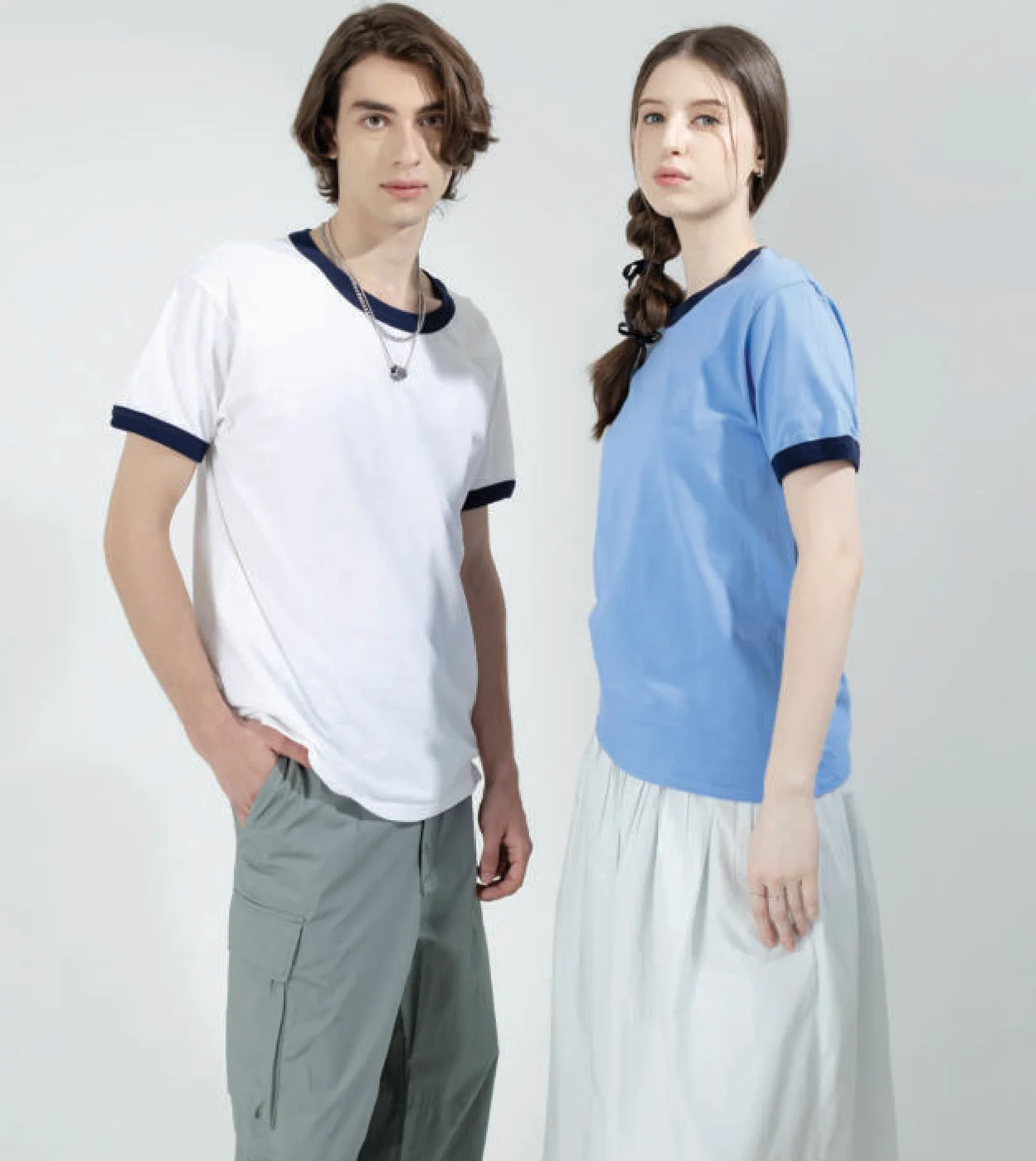 Two people wearing Gildan 76600 ringer tees: white with navy bands, and carolina blue with navy bands