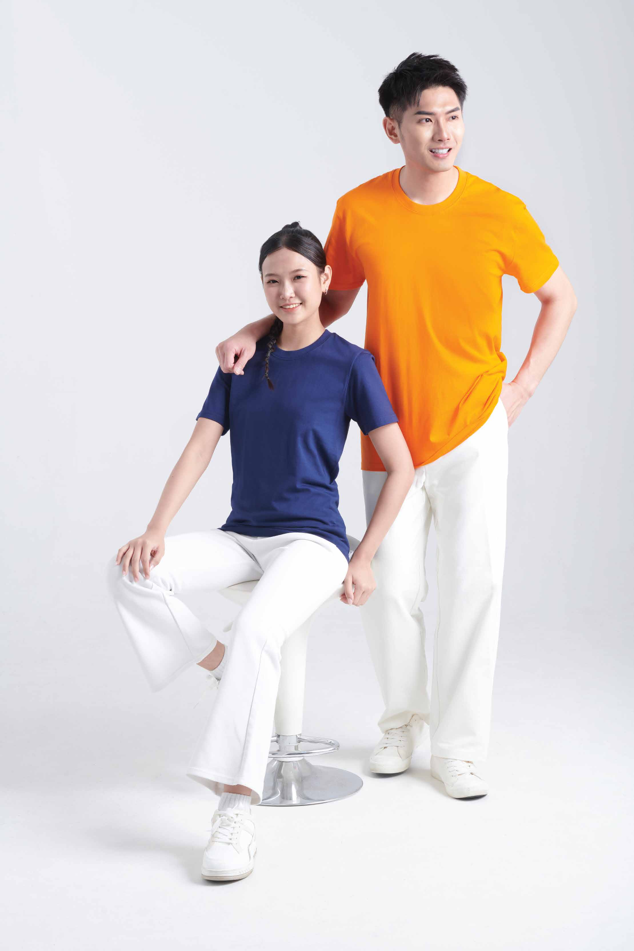 Two people wearing Oren RN60 round neck cotton t-shirts in orange and navy